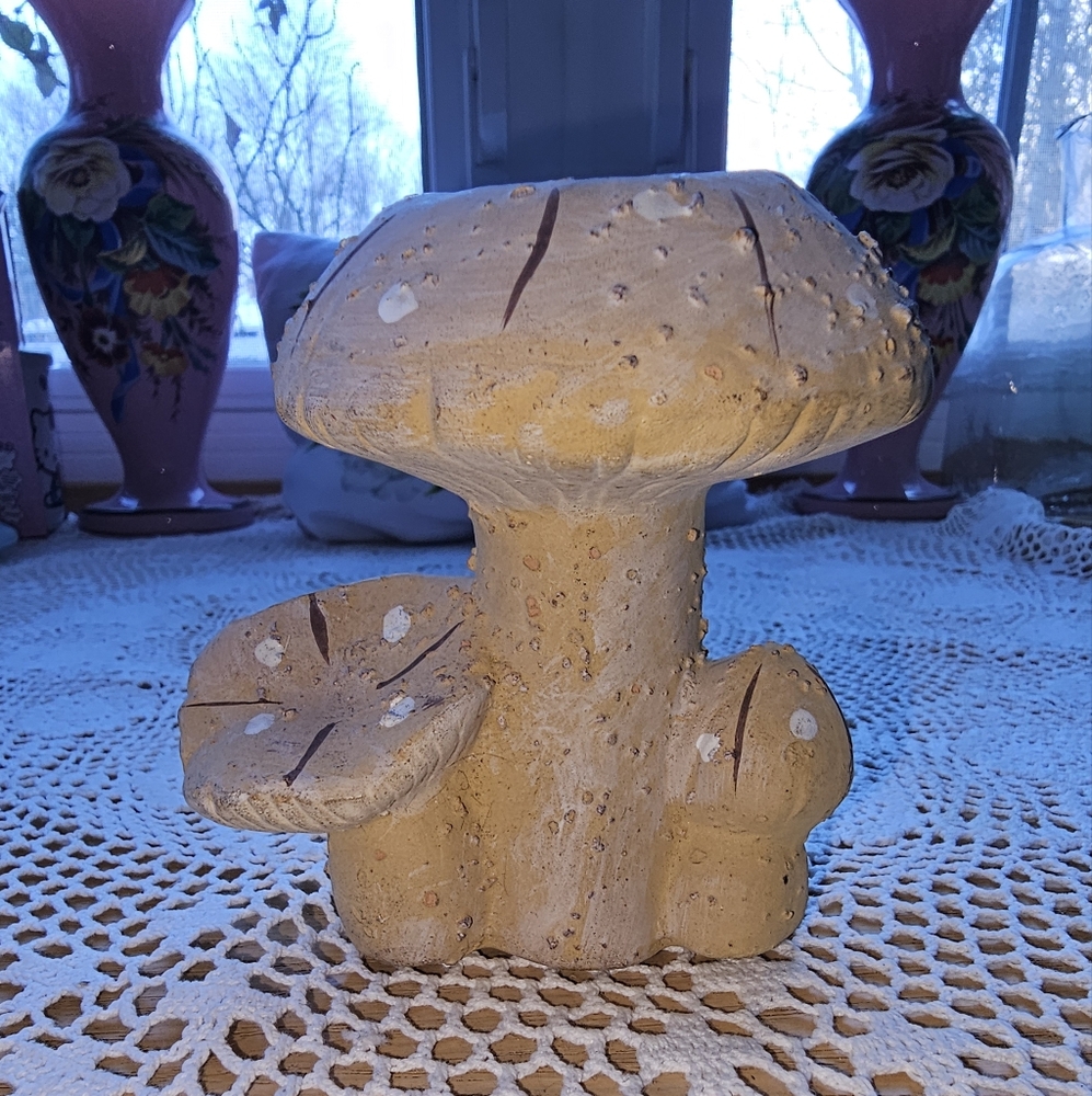 Ceramic mushroom candle with two small mushrooms on each side.